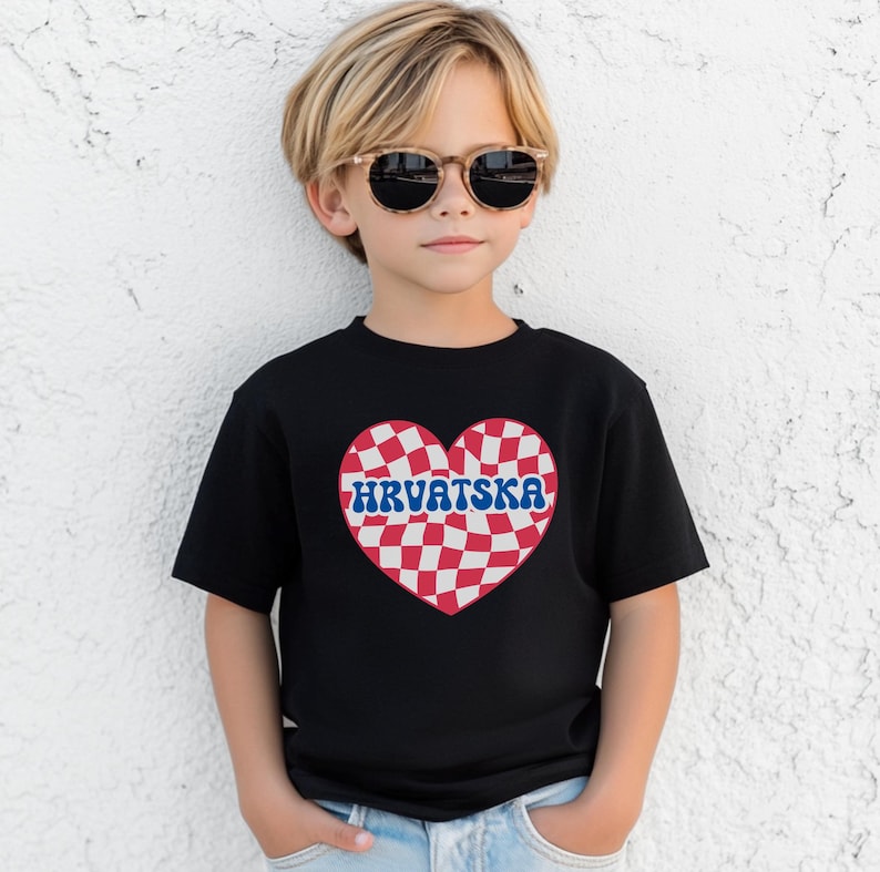 Puede incluir: Una camiseta negra con un dise&ntilde;o de coraz&oacute;n a cuadros rojos y blancos. El coraz&oacute;n tiene la palabra "HRVATSKA" escrita en letras azules.