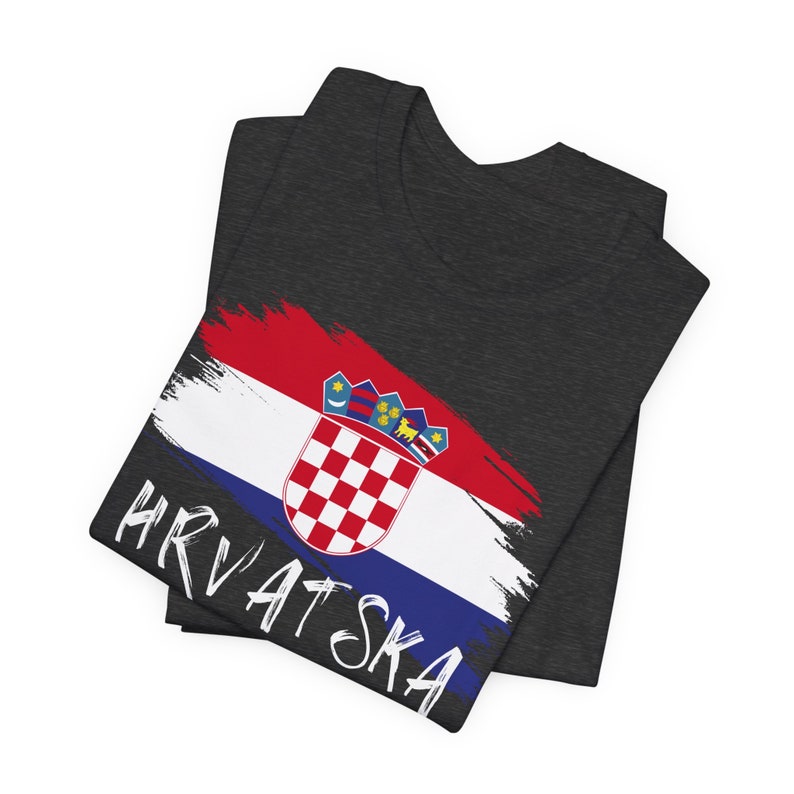 May include: A dark grey t-shirt with a white paint-splattered Croatian flag and the word "HRVATSKA" in white lettering.