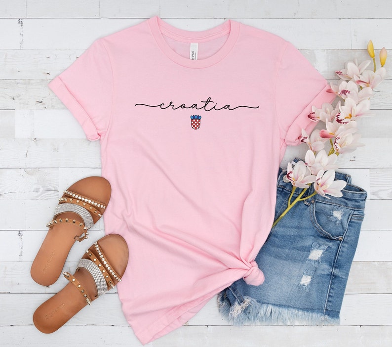 May include: Pink t-shirt with the word "croatia" written in cursive with the Croatian coat of arms underneath.