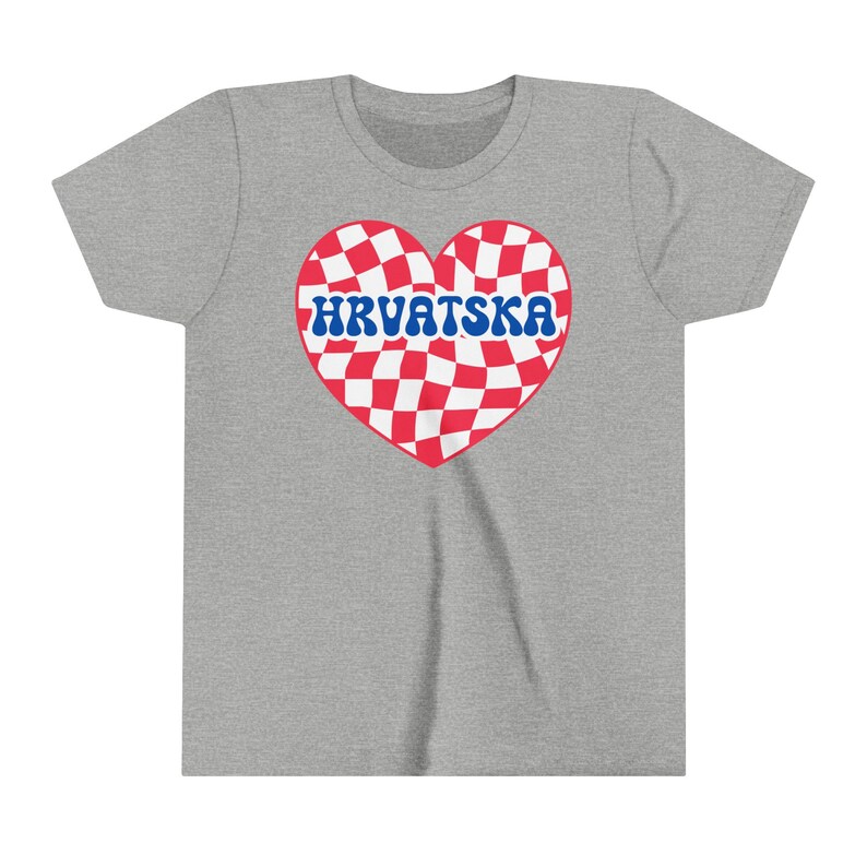 Puede incluir: Una camiseta gris con un dise&ntilde;o de coraz&oacute;n a cuadros rojos y blancos. El coraz&oacute;n tiene la palabra "HRVATSKA" escrita en letras azules.