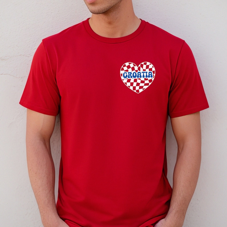 Puede incluir: Camiseta roja con un coraz&oacute;n a cuadros blancos y rojos con la palabra "CROATIA" en letras azules.