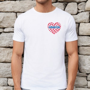 Puede incluir: Camiseta blanca con un coraz&oacute;n a cuadros rojo y blanco con la palabra "CROATIA" en letras azules.