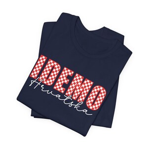 May include: A navy blue t-shirt with a red and white checkered design that says "IDEMO Hrvatska".