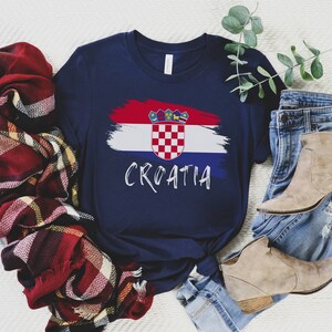 K&ouml;nnte beinhalten: Ein marineblaues T-Shirt mit einem kroatischen Flaggen-Design in Wei&szlig;, Rot und Blau und dem Wort "CROATIA" in wei&szlig;er Schrift.