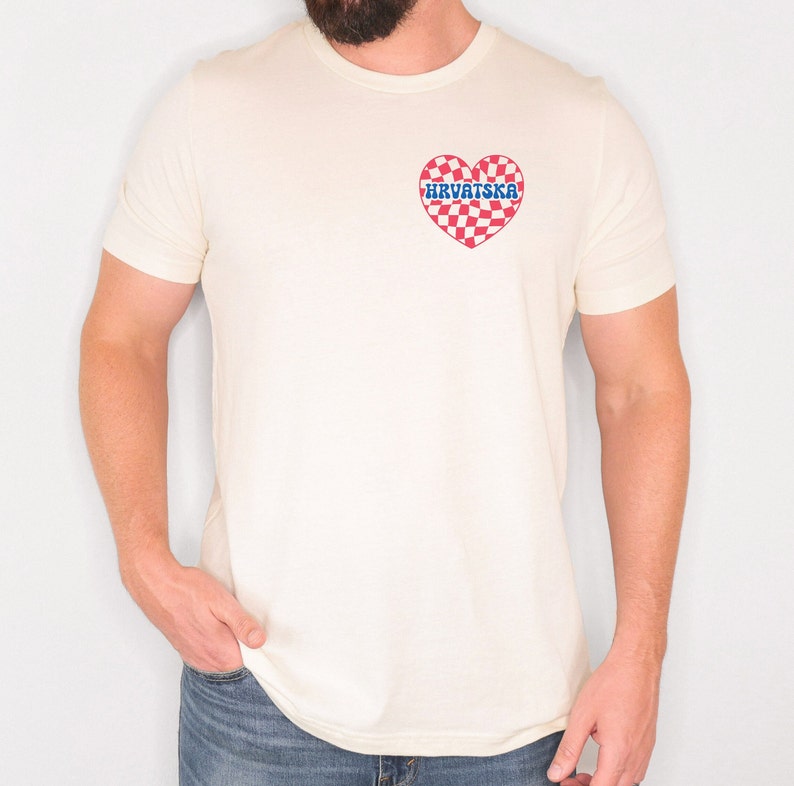Pu&ograve; includere: Una maglietta bianca con un cuore a scacchi rosso e bianco con la parola "HRVATSKA" in lettere blu.
