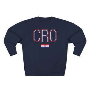 May include: Navy blue sweatshirt with the word "CRO" in red, white and blue outlined letters. A small Croatian flag is below the letters.