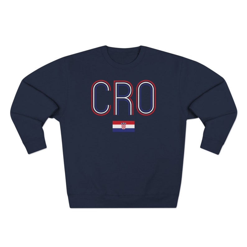 May include: Navy blue sweatshirt with the word "CRO" in red, white and blue outlined letters. A small Croatian flag is below the letters.