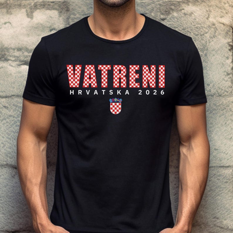 May include: Black t-shirt with the word "VATRENI" in a red and white checkered pattern. Below the word is "HRVATSKA 2026" in white text. A Croatian coat of arms is below the text.