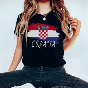 K&ouml;nnte beinhalten: Schwarzes T-Shirt mit einer wei&szlig; bemalten kroatischen Flagge und dem Wort "CROATIA" in wei&szlig;er Schrift.