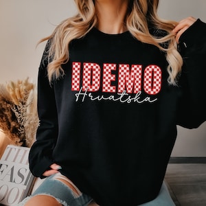 May include: Black sweatshirt with a red and white checkered graphic that says "IDEMO Hrvatska".