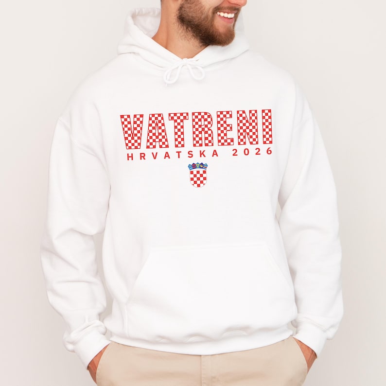 May include: White hoodie with a front pocket and drawstring. The front features the word "VATRENI" in red checkered letters, "HRVATSKA 2026" in red, and a Croatian coat of arms.