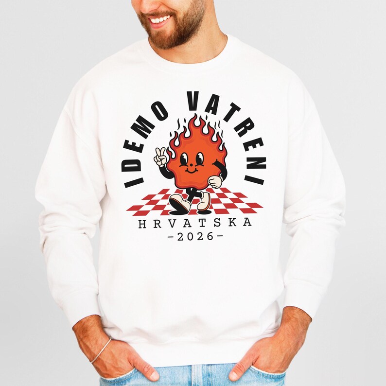 May include: White sweatshirt featuring a cartoon flame character with the text "IDEMO VATRENI" and "HRVATSKA - 2026". The design includes a red and white checkered pattern and a peace sign.