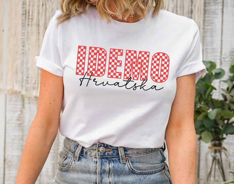 May include: White t-shirt with a red and white checkered design that spells out "IDEMO" and the text "Hrvatska" in black script.