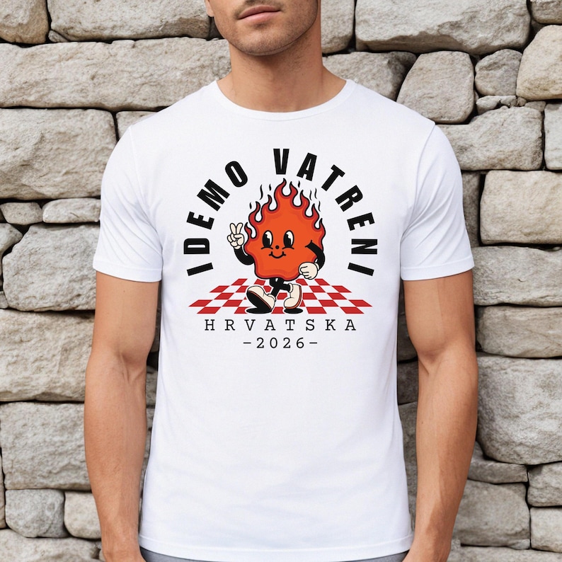 May include: White t-shirt featuring a cartoon flame character with the text "IDEMO VATRENI" and "HRVATSKA - 2026". The flame character is red with black accents, standing on a red and white checkered pattern.