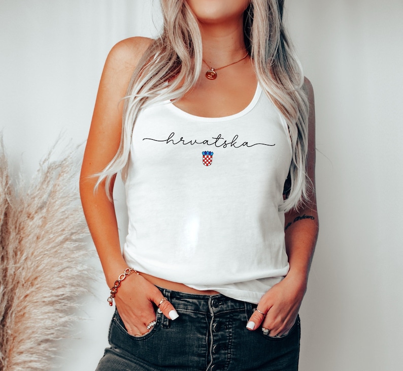 May include: White tank top with the word "hrvatska" written in black script and a red, white, and blue Croatian coat of arms.