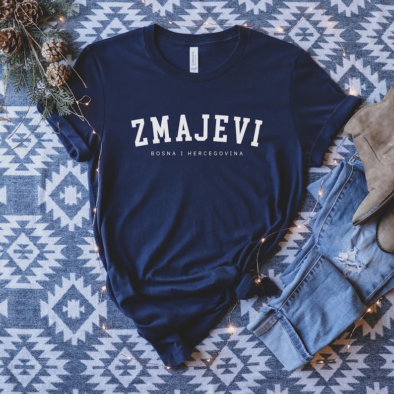 Op de afbeelding: Een marineblauw t-shirt met witte tekst die "ZMAJEVI" en "BOSNA I HERCEGOVINA" zegt.