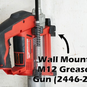 May include: A red and black cordless grease gun with a wall mount. The grease gun is labeled "M12 Grease Gun (2446-20)".