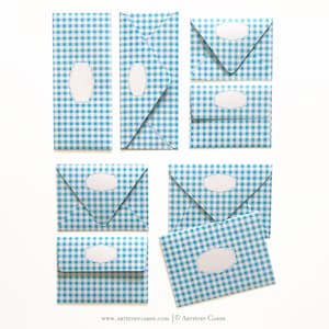 May include: Set of eight blue and white gingham envelopes with white labels. The envelopes are in various sizes and shapes, including a long rectangular envelope, a square envelope, and a triangular envelope.