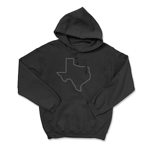 May include: A black hooded sweatshirt with a gray outline of the state of Texas on the front. The sweatshirt has a kangaroo pocket and a drawstring hood. The image is on a white background.