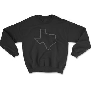 May include: Black sweatshirt with a gray outline of the state of Texas. The long-sleeved crewneck top is made of a soft material and is laid flat on a white surface. The Texas outline is centered on the front of the shirt.