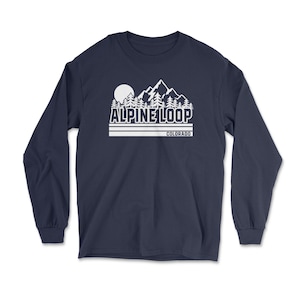May include: Navy blue long-sleeve shirt with a white graphic of a mountain range, trees, and a sun. The text "ALPINE LOOP COLORADO" is printed below the graphic in white. The shirt is made of a soft, comfortable material.