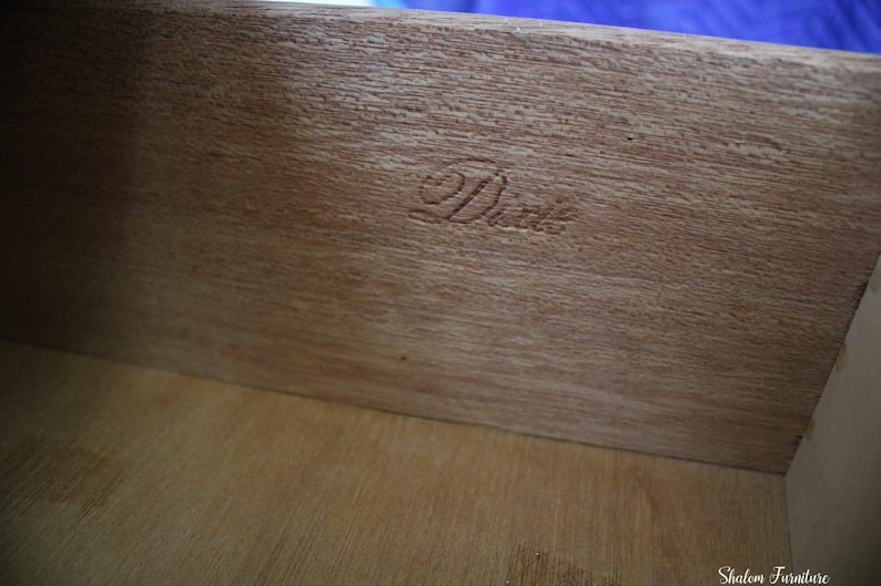 May include: Close-up of a wooden drawer interior with the word "Dixie" stamped in the wood.