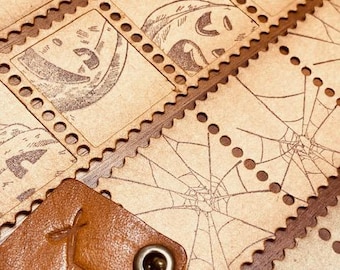 May include: A collection of vintage-style postage stamps with various Halloween-themed designs, including a spider web, a jack-o-lantern, and a beetle. The stamps are printed on brown paper and have a distressed, aged look. A brown leather keychain with a decorative design is in the foreground.