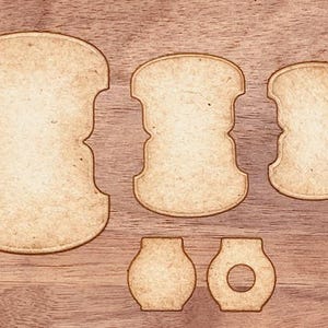May include: Five wooden shapes, cut out from a sheet of brown paper. The shapes are all different sizes and have a slightly distressed look. The shapes are perfect for crafting or scrapbooking.