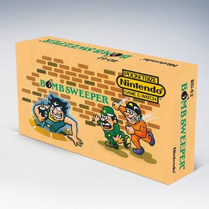 以下が含まれることがあります： ヴィンテージの任天堂ゲーム＆ウォッチ「ボムスイーパー」携帯ゲーム機の箱。箱はタン色で、漫画のキャラクターとゲームタイトルのカラフルなイラストが描かれています。任天堂のロゴと「ポケットサイズ」も表示されています。