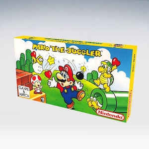 以下が含まれることがあります： マリオ・ザ・ジャグラーのヴィンテージゲーム＆ウォッチボックス。ボックスは黄色の縁取りで、マリオ、クッパ、その他のキャラクターのカラフルなイラストが描かれています。任天堂のロゴが見えます。