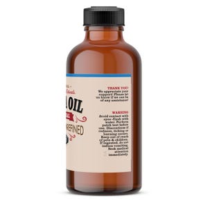 May include: A brown glass bottle with a black cap, labeled "Natural Oil Unrefined". The label also includes a warning about avoiding contact with eyes and performing a patch test before use.