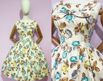 Vestido vintage de los años 50 y 50 con estampado floral en beige, azul y blanco, falda larga y estilo pin-up.