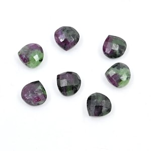 May include: Seven green, pink, and purple heart-shaped gemstones.