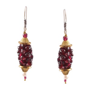 May include: A pair of dangle earrings with a gold-toned metal setting and a cluster of deep red garnet-like beads.