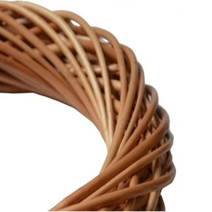 May include: Close-up of a natural woven wreath made of brown wicker.