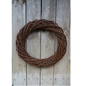May include: A brown woven wreath made of natural twigs, perfect for decorating a door or wall.