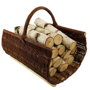 May include: A brown wicker basket filled with birch logs. The basket has a curved handle and is made of woven brown material. The birch logs have a white and black bark.