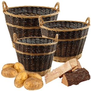 May include: Three brown wicker baskets of varying sizes with woven handles. The baskets are stacked on top of each other. There are some potatoes and pieces of firewood in front of the baskets.
