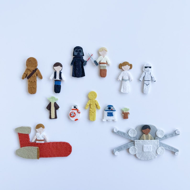 May include: Felt characters from the Star Wars franchise, including Darth Vader, Chewbacca, Luke Skywalker, Princess Leia, R2-D2, C-3PO, Yoda, and a TIE fighter.