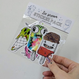 May include: A pack of four vinyl stickers featuring colorful ice cream themed illustrations. The stickers are in a clear plastic bag with a white header that reads "Ice cream STICKER PACK 4 VINYL STICKERS".