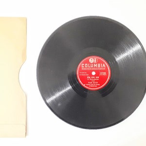 May include: A black vinyl record with a red Columbia label. The label has the text "Columbia" and "37280" in white. The record is titled "Sing, How, Now" by "Patti Page".