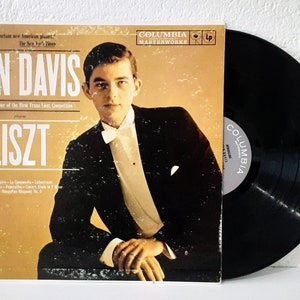 May include: A vintage vinyl record album cover featuring a black and white photo of Ivan Davis, a pianist, in a tuxedo. The album title is "Liszt" and the record label is Columbia Masterworks.