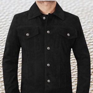 May include: A black suede jacket with a classic denim jacket style. It has a button-up front, two chest pockets, and long sleeves.