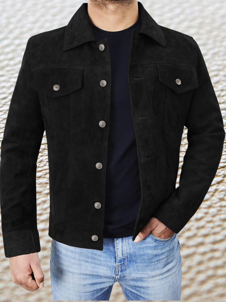 May include: A black suede jacket with a button-up front and a classic denim jacket style. The jacket has a pointed collar, two chest pockets, and two front pockets.