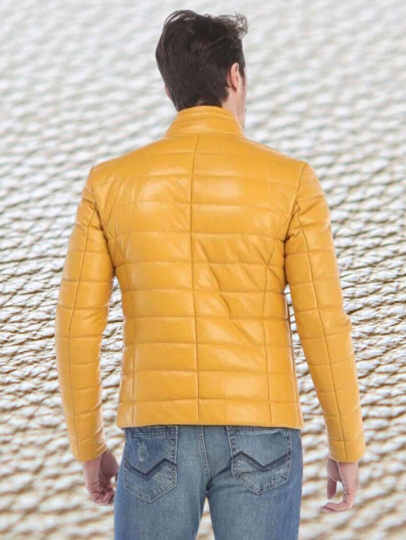 May include: A yellow quilted leather jacket with a zipper closure. The jacket has a stand-up collar and long sleeves.