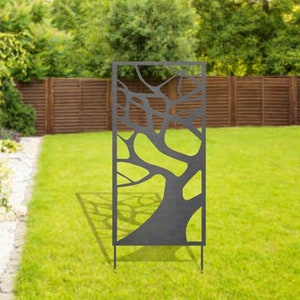 May include: A black metal garden screen with a tree branch design. The screen is freestanding and has four legs.