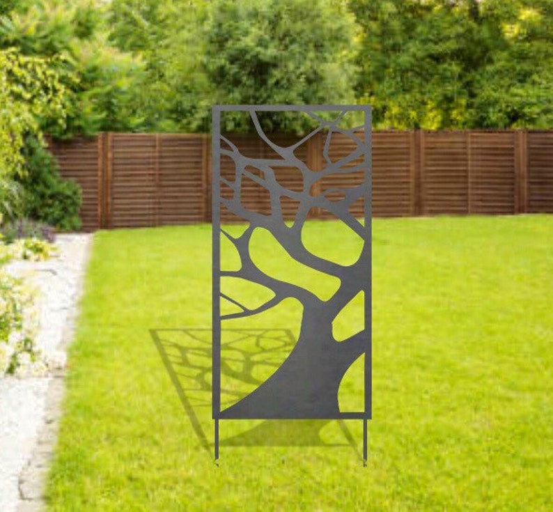May include: A black metal garden screen with a tree branch design. The screen is freestanding and has four legs.