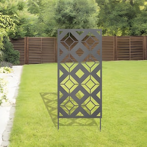May include: A black metal garden screen with a geometric diamond pattern. The screen is standing on a green lawn.
