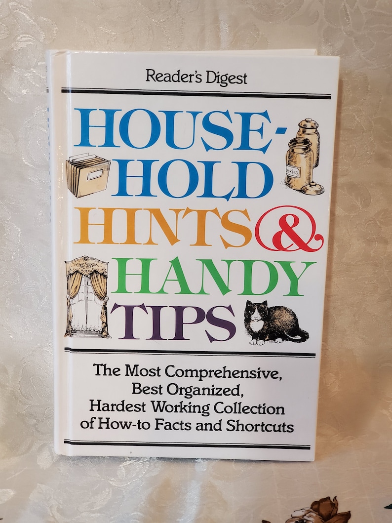 May include: A white book with a colorful title that reads "HOUSEHOLD HINTS & HANDY TIPS". The book is published by Reader's Digest and features the text "The Most Comprehensive, Best Organized, Hardest Working Collection of How-to Facts and Shortcuts".