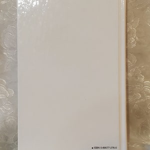 May include: White book with a glossy cover and black text on the back that reads "ISBN 0-89577-276-0".